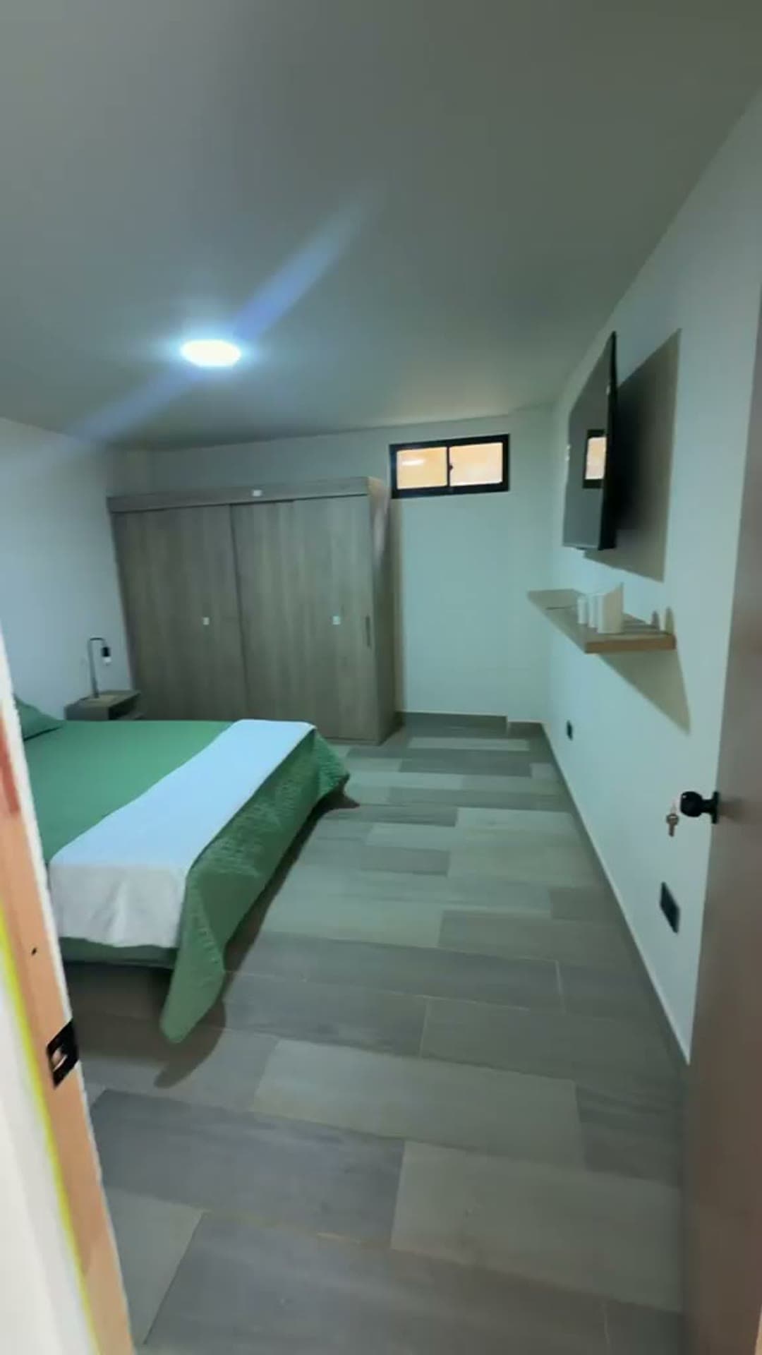 Alcoba principal con cama verde y closet